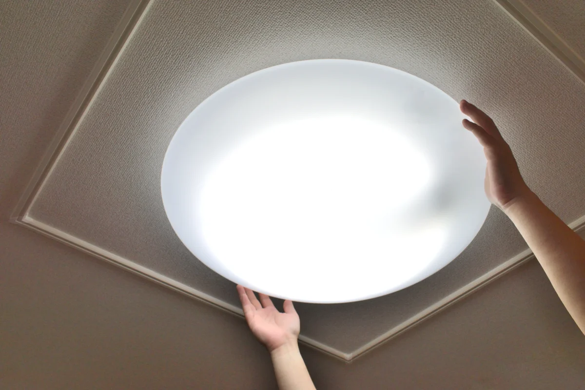 天井のシーリングライトを取り付ける作業